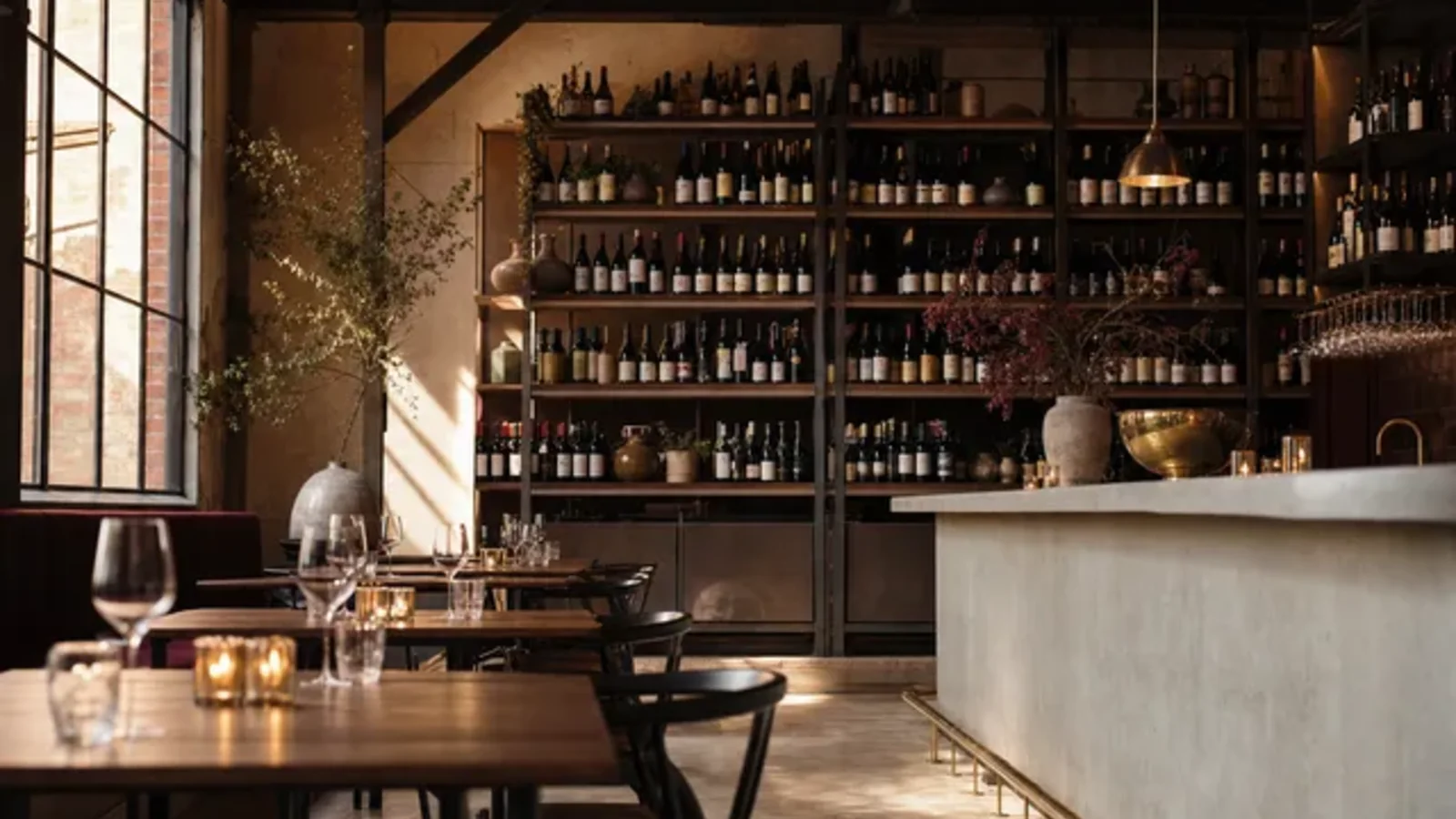 Illustrative wine-bar interior — candlelit tables, a marble counter and a wall of bottles — evoking the Geelong Wine Region's evening wine culture. An AI-generated scene, not a photograph of a specific venue.